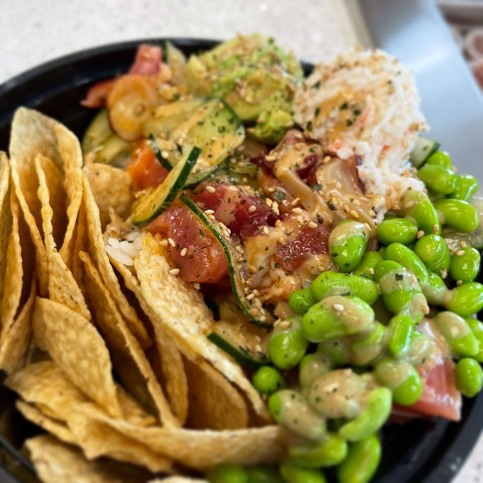 A Poki Bowl with tuna, avocado, edamame, crab salad, cucumbers, and tortilla chips.